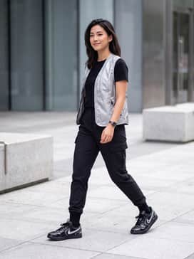 Black nylon cargo pants with a fitted silver-toned bodysuit and a cropped utility vest for a futuristic techwear look.