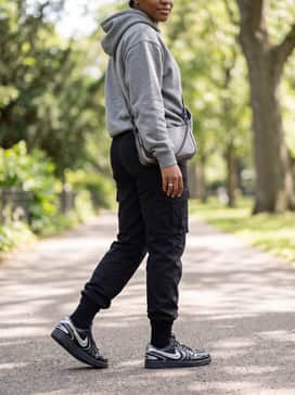 Relaxed-fit black joggers and a heavyweight grey hoodie paired with a metallic chain crossbody bag to coordinate with the shoe's textures.
