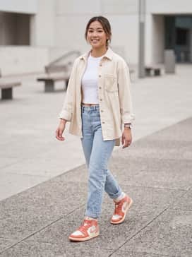 Air Jordan 1 Mid – Light-wash straight-leg jeans paired with a white cropped baby tee and an unbuttoned cream flannel for a relaxed 90s-inspired look.