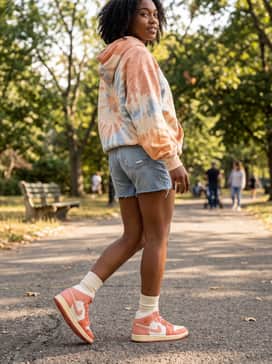 Air Jordan 1 Mid – Distressed denim shorts and an oversized sunset-toned tie-dye hoodie for a comfortable and cohesive weekend outfit.