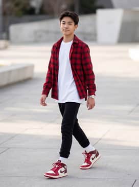 Air Jordan 1 Mid – A pair of slim-fit black joggers paired with an oversized white graphic t-shirt and a matching red flannel shirt worn open for a layered streetwear look.