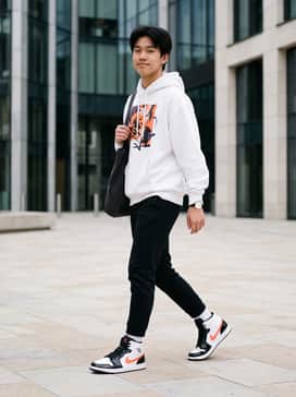 Pair with black tapered joggers and an oversized white hoodie featuring a pop of orange in the graphics to mirror the shoe's swoosh.