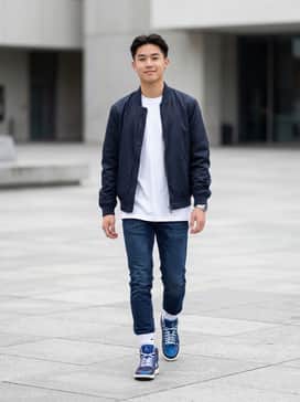 Dark wash slim-fit denim jeans, a crisp white oversized graphic tee, and a matching navy bomber jacket for a cohesive urban look.