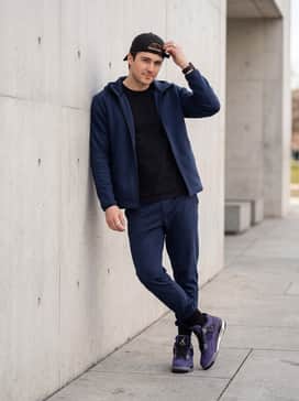 Air Jordan 4 Retro Imperial Purple – Go for a coordinated athletic vibe with navy blue track pants, a matching black tech-fleece zip-up jacket, and a simple black adjustable baseball cap.