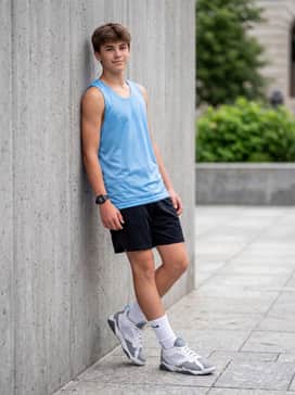Black athletic shorts with white crew socks pulled high, paired with a moisture-wicking light blue performance jersey for a court-ready look.