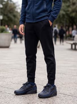 Tapered black tech-fleece joggers with a matching navy blue zip-up athletic jacket for a streamlined, sporty aesthetic.