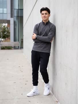 Black tech-fleece joggers combined with a charcoal grey performance quarter-zip pullover to create a modern, athletic silhouette that emphasizes comfort.