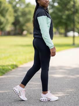 Black performance leggings styled with a moisture-wicking mint green tank top and a sleek white baseball cap for a sporty, active vibe.