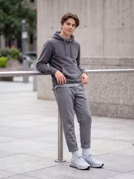 Weekend street style: Style with light-wash distressed denim jeans, a graphic t-shirt in cool tones, and an unbuttoned grey flannel shirt for a relaxed yet curated appearance.