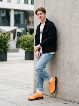 Air Max Dn8 – Casual weekend attire consisting of light-wash tapered jeans, a white oversized graphic tee, and a black denim jacket.