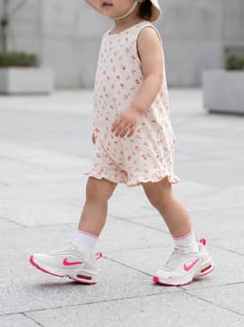 For a toddler, a soft cotton cream-colored romper with small pink floral patterns, paired with a matching pink sun hat for a coordinated look.