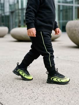 A black cotton tracksuit with subtle neon green piping to echo the shoe's vibrant accents.