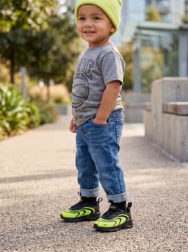 Classic blue denim cuffed jeans paired with a grey graphic t-shirt and a matching volt-colored beanie.