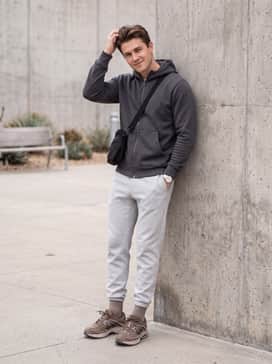 Air Max Moto 2k – Grey tech-fleece joggers with a matching charcoal zip-up hoodie and a black tactical crossbody bag for a modern urban techwear vibe.