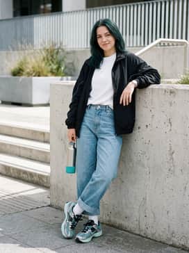 Relaxed-fit light-wash jeans with a tucked-in oversized white graphic t-shirt and silver chunky jewelry to complement the sneaker's metallic overlays.