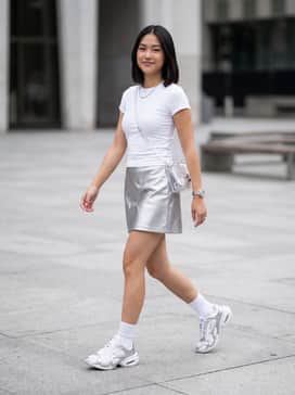 A metallic silver mini skirt paired with a fitted white baby tee and translucent accessories to embrace a full Y2K aesthetic.