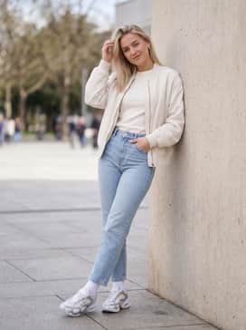 Air Max Muse – Straight-leg light-wash denim jeans with a tucked-in oversized graphic t-shirt and a cropped puffer jacket for a classic streetwear vibe.
