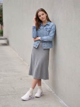 Air Max Nuaxis Se – A grey knit midi-dress layered with a classic light-blue denim jacket and minimalist silver jewelry to highlight the sneaker's metallic swoosh.