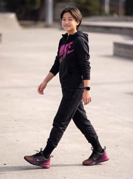 Pair these sneakers with black fleece joggers and a matching zip-up hoodie featuring a bright pink graphic logo for a cohesive, athletic look.