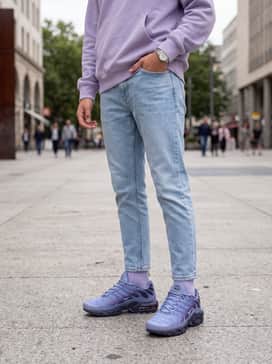 Light-wash tapered denim jeans worn with a lavender-colored oversized hoodie to complement the sneaker's primary gradient tones.