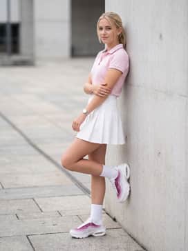 Air Max Portal – Style with a white pleated tennis skirt, a pastel pink tucked-in polo, and white crew socks to embrace a modern 'tennis-core' aesthetic.