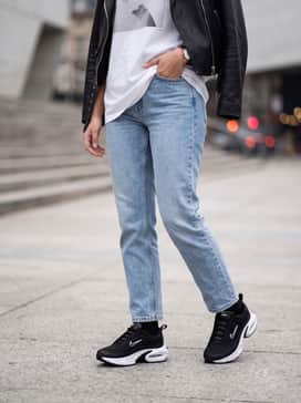 Air Max Portal – Light-wash straight-leg denim jeans with a tucked-in oversized white graphic tee and a black leather moto jacket.