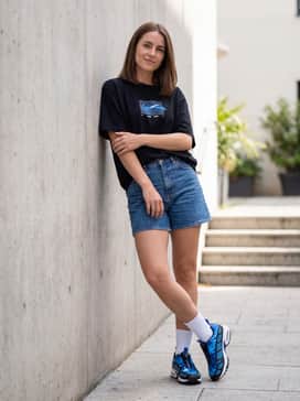 Air Max Sndr Camo – Style with high-waisted denim shorts, a matching blue graphic t-shirt, and tall white crew socks for a retro-sporty summer vibe.