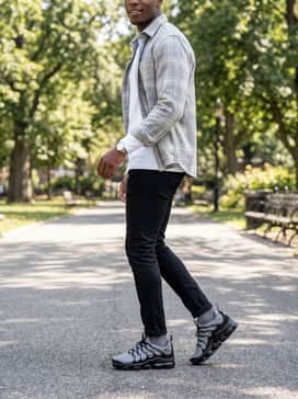 Slim-fit black denim with a white long-sleeve shirt and a light grey flannel overshirt for a clean, layered casual look.