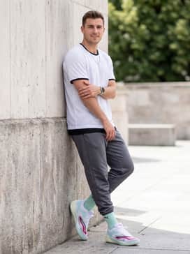 Allpro Nitro 2 – A summertime streetwear ensemble with light-wash denim shorts, a clean white button-down shirt worn open over a black ribbed tank, and a silver chain necklace.