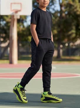 Anthony Edwards 1 Low Basketball Shoes Kids – Tapered black tech-fleece joggers paired with a heather gray oversized hoodie for a sleek, modern streetwear silhouette.