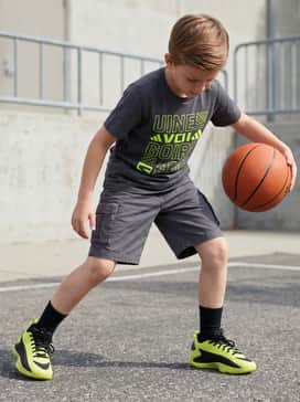 Durable charcoal cargo shorts and a graphic t-shirt featuring bold typography to match the shoe's energetic vibe.