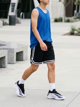 Pair with black mesh basketball shorts featuring white side stripes and a vibrant blue jersey to echo the shoe's accent color, finished with white cushioned crew socks.