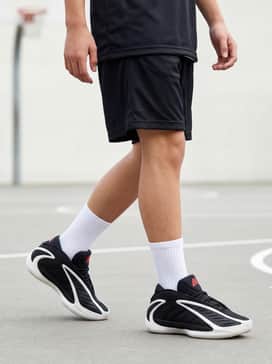 A black moisture-wicking basketball jersey paired with matching mesh shorts and high-profile white crew socks to highlight the shoe's futuristic design.
