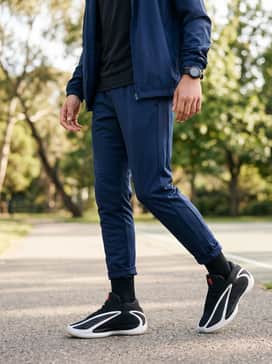Anthony Edwards 2 Shoes Kids – Navy blue athletic track pants with side-striping, a breathable performance t-shirt, and a matching zip-up windbreaker for a complete athletic look.