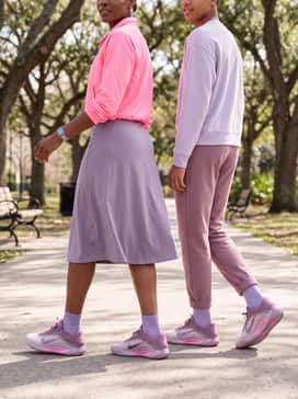 Aone Dog Mom – A black athletic tennis skirt matched with a cropped neon pink windbreaker to echo the vibrant accents on the midsole.
