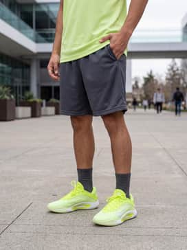 Style with charcoal grey mesh basketball shorts and a matching lime green performance jersey for a cohesive, athletic look on or off the court.