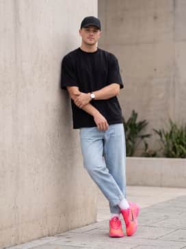 Aone Warning Label – Bold Streetwear: Pair with loose-fit light-wash jeans and a black boxy-cut graphic tee, finished with a matching pink baseball cap.