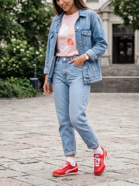 Light-wash high-waisted mom jeans with a tucked-in pink graphic tee and an oversized denim jacket for an effortless weekend vibe.