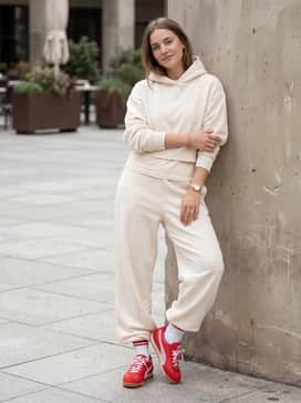 An all-cream loungewear set consisting of wide-leg sweatpants and a cropped hoodie to let the vibrant red and pink colors stand out.