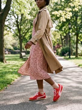 A floral midi dress in a complementary red print, layered with a tan trench coat that echoes the gum sole for a balanced, chic ensemble.
