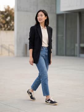 Astrograbber Leather – High-waisted straight-leg vintage denim paired with a tucked-in cream knit polo and an oversized black blazer for a sophisticated 'off-duty' look.