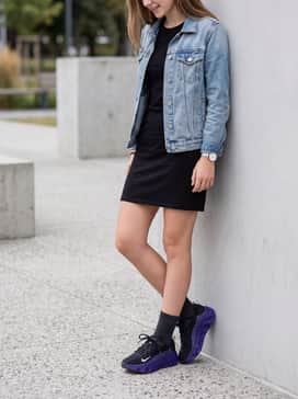 A casual black t-shirt dress layered under a light-wash denim jacket for a comfortable weekend outfit.