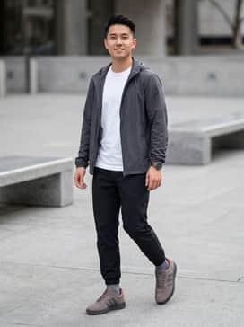 Barreda Decode Shoes Audi Revolut F1 Team Shoes – A motorsport-inspired ensemble featuring black tapered technical joggers, a white Audi F1 team graphic tee, and a lightweight charcoal windbreaker.