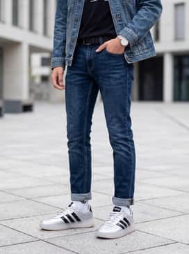 Dark wash slim-fit jeans with a classic black graphic t-shirt and a denim jacket for a timeless casual ensemble.