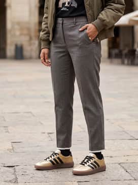 Straight-leg light-wash denim jeans with a tucked-in black graphic t-shirt and a cropped olive bomber jacket for a classic urban look.