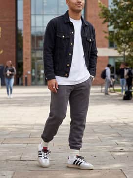 Relaxed-fit grey joggers and a crisp white oversized hoodie, topped with a black denim jacket to emphasize the shoe's streetwear silhouette.