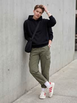 Barreda Shoes – Relaxed-fit olive green cargo trousers with a black oversized hoodie and a crossbody bag for a contemporary urban streetwear vibe.