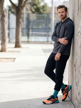 A sleek athleisure outfit with slim black tech-fleece pants and a lightweight grey hoodie, perfect for traveling to and from the court.