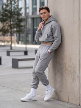 Grey high-waisted fleece joggers and a matching cropped hoodie with white crew socks pulled over the hems for a clean athleisure vibe.