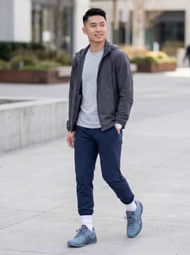 Beyond Ff – A performance-driven court look featuring navy blue tapered athletic joggers, a moisture-wicking charcoal grey t-shirt, and a lightweight white zip-up windbreaker.